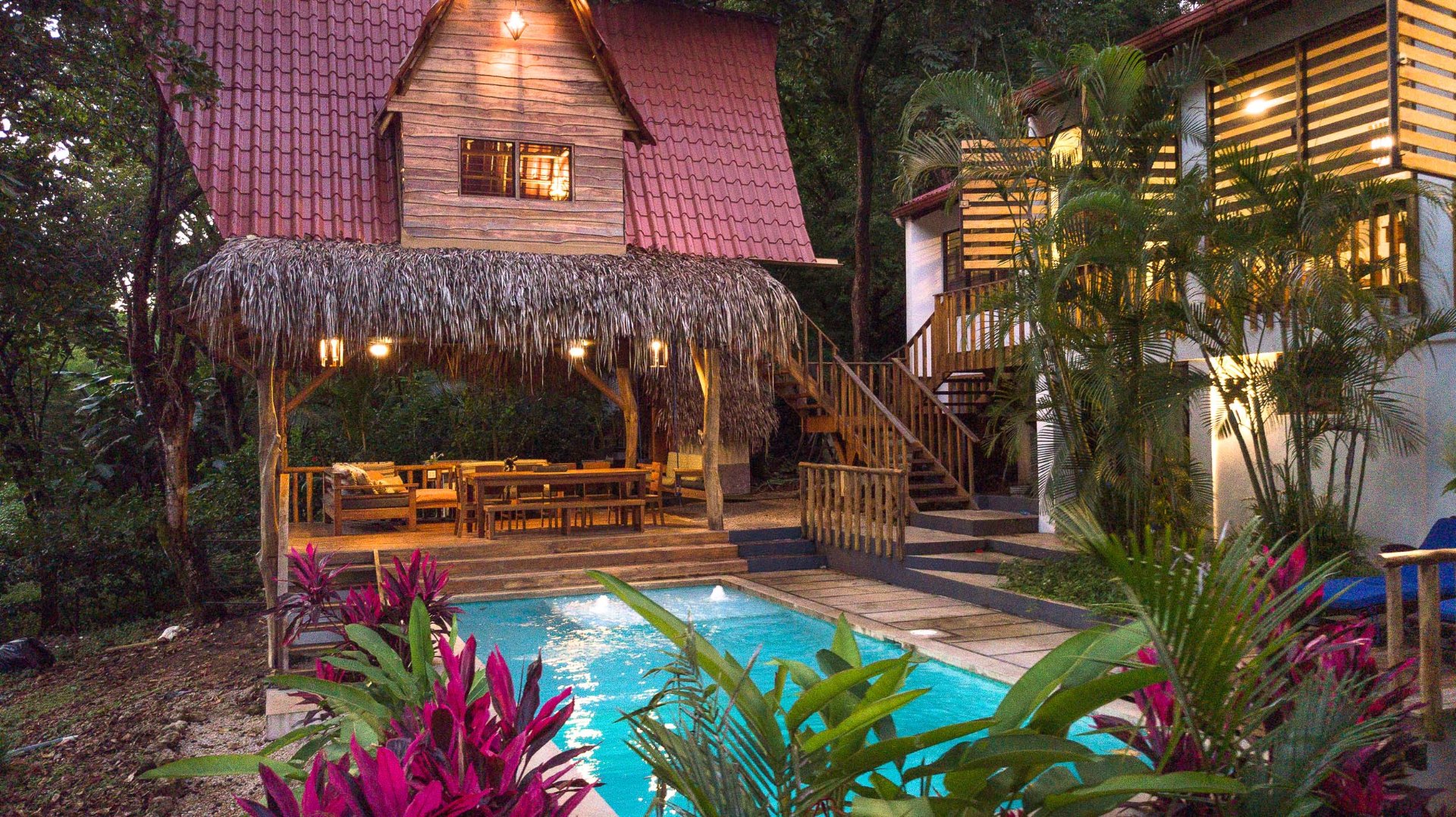 Hacienda Nosara at twilight — Almendras rancho, saltwater pool, and illuminated guest suites