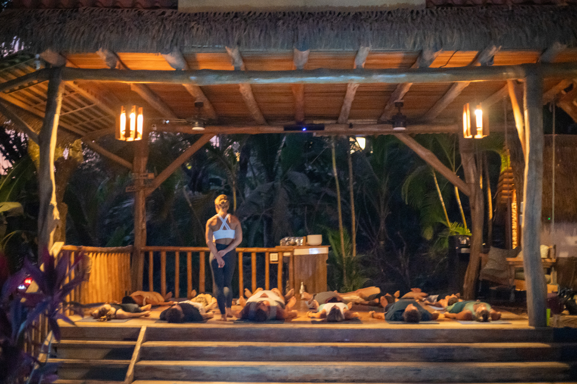 Candle-lit savasana at night in the open-air rancho beneath the treehouse.